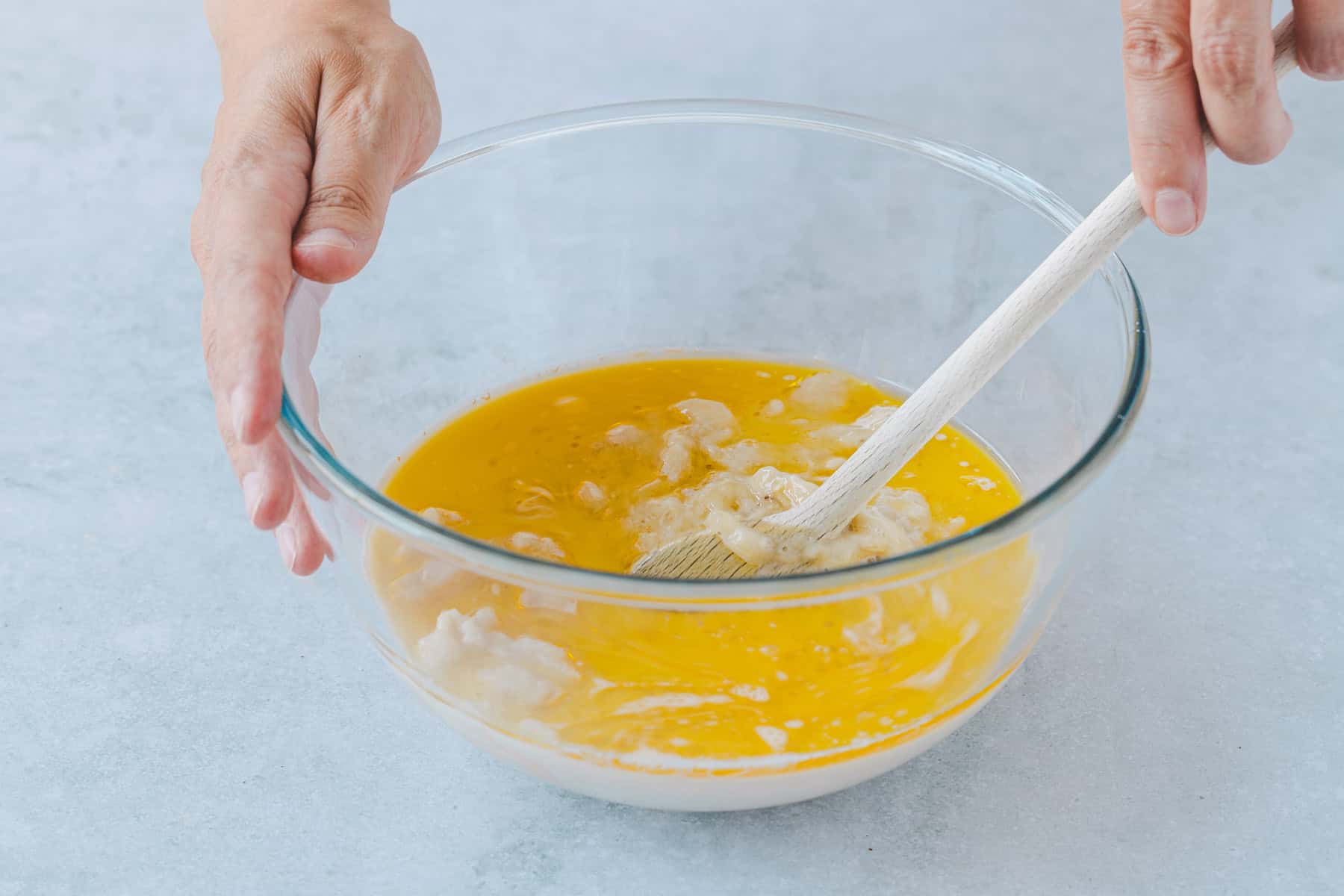 Teig für Bananenbrot ohne Ei wird verrührt. Öl, Ahornsirup und Hafermilch werden mit den zerdrückten Bananen vermengt.