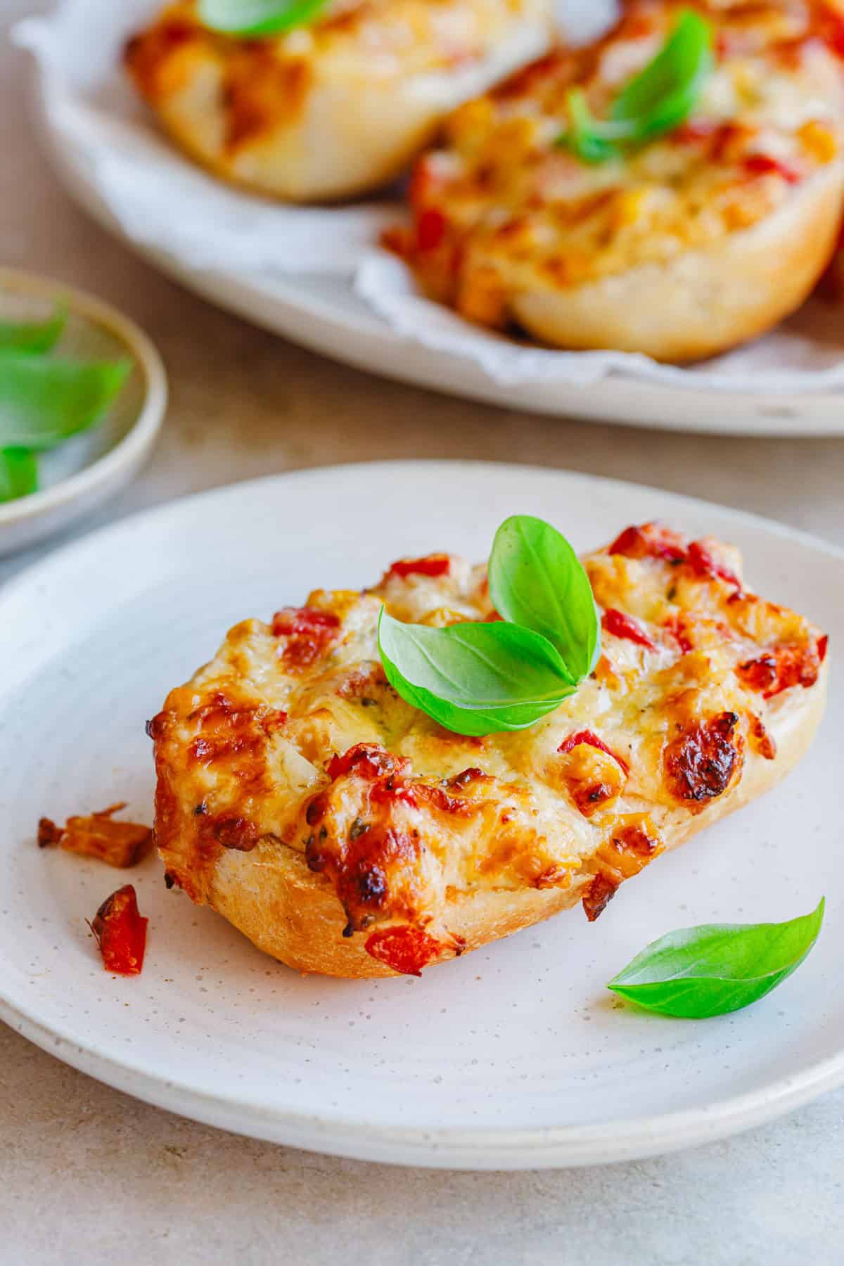 Pizzabrötchen vegetarisch mit Schmand auf einem Teller.